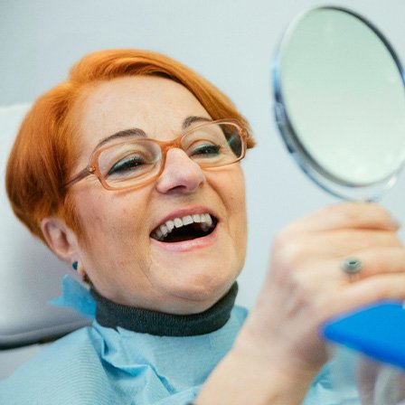 An older woman admiring her restored smile
