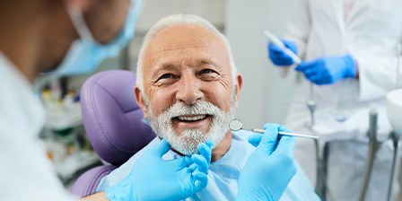 Man with white hair and beard in dental chair about to have exam