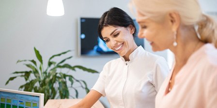 Smiling dental assistant showing patient forms