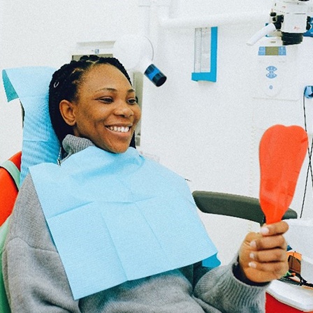 Woman in dentist’s chair looking in a mirror