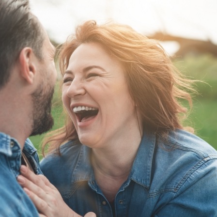Man and woman laughing outside together