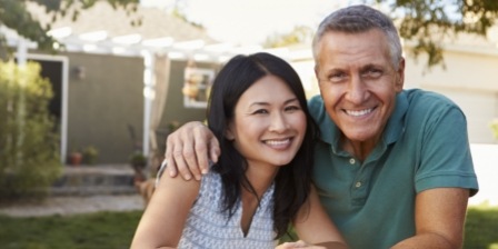 Man and woman smiling in their front yard