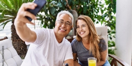 Man and woman taking selfie at breakfast table