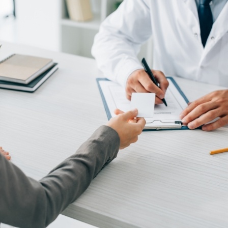 A patient handing a payment card to their dentist