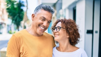 Man and woman smiling together on city sidewalk