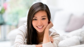 Smiling woman laying on white bed