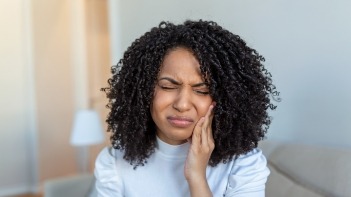 Woman holding her cheek in pain