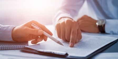 Two people looking at form on clipboard