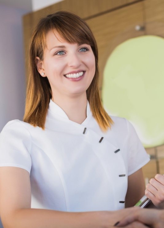 Smiling dental receptionist shaking hands with a patient