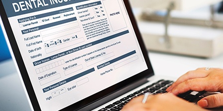 Filling out a dental insurance form on a laptop