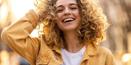 Woman in yellow jacket outside and smiling