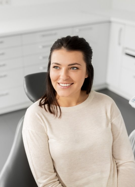 Woman smiling as her dentist explains post op instructions