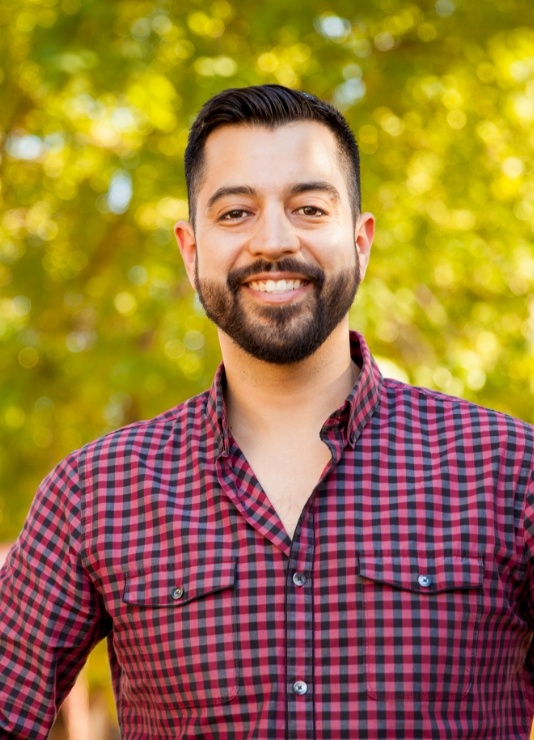 Man in red and black plaid shirt smiling after preventive dentistry