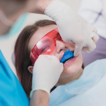 Woman in dental chair with fluoride trays over her teeth