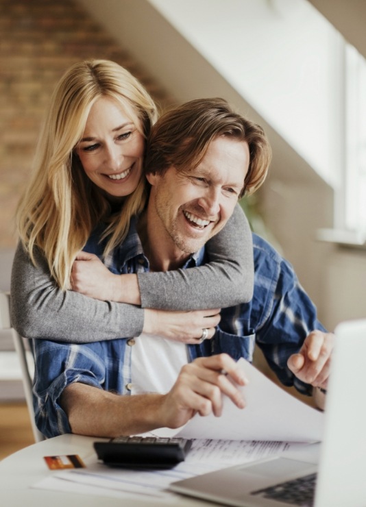 Man and woman looking at laptop for dentist reviews in Oklahoma City