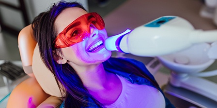 Woman undergoing teeth whitening at dental office