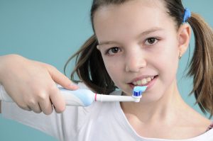 little girl smiling brushing teeth