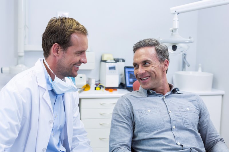 person talking with dentures to dentist