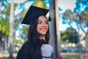 Smiling woman in black cap and gown