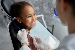 Little girl in dentist's chair smiling